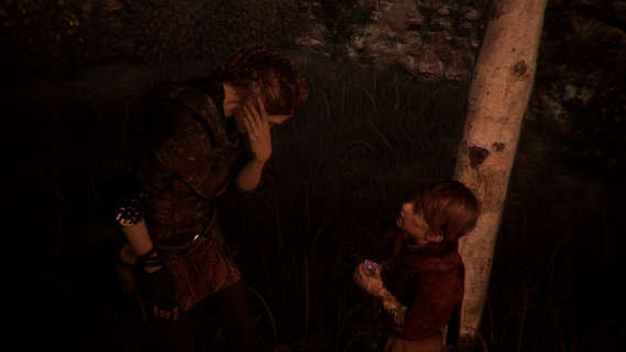 Hugo offers a violet to his sister Amicia, who bends down to allow him to put it in her hair.